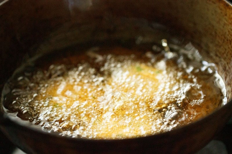 Masala vada in sizzling hot oil in a kadai (wok).