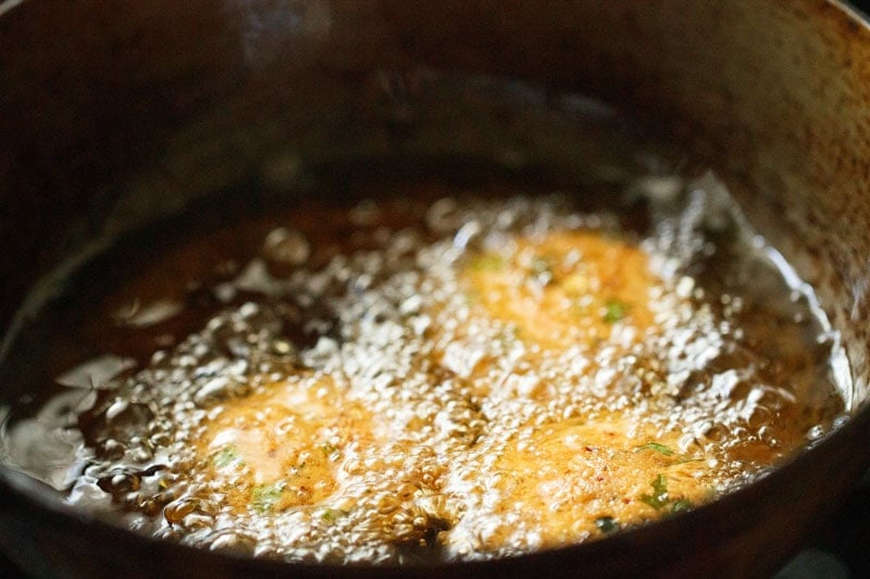 Frying masala vada in hot oil.