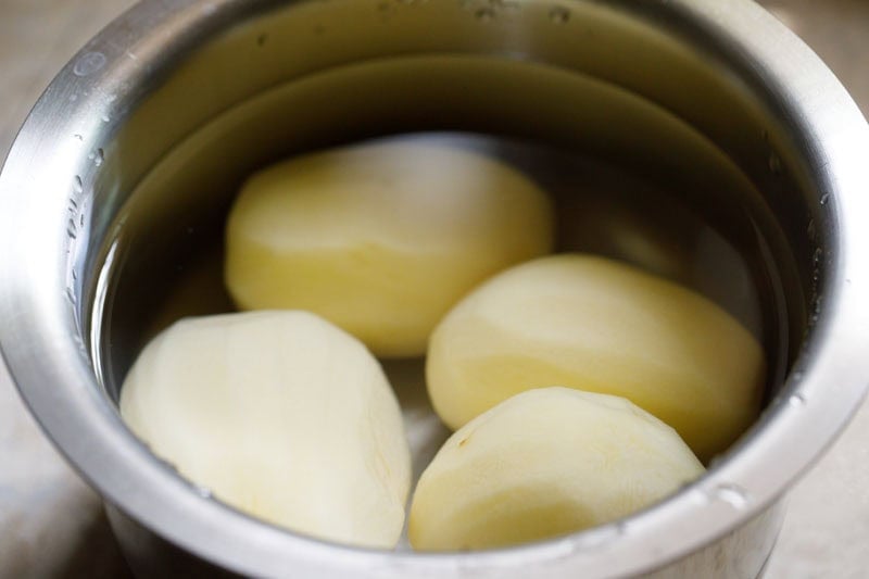 Peeled potatoes soaking in water.