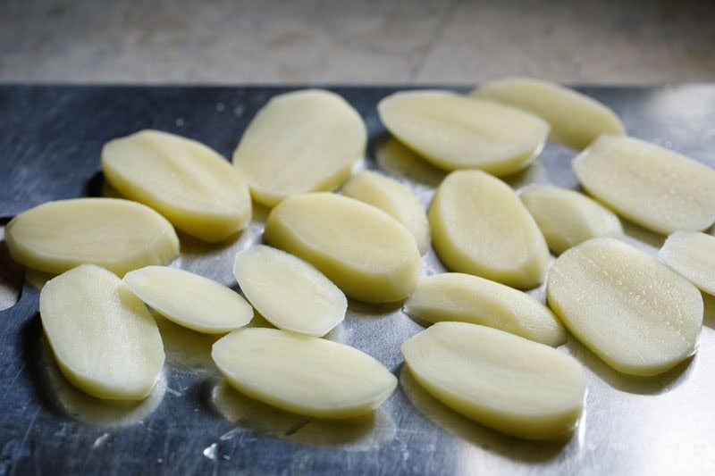 Sliced potatoes on chopping tray.