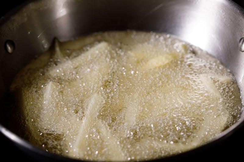 Potato fries in bubbling and sizzling hot oil.