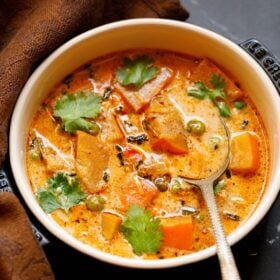 Pumpkin curry in a bowl with spoon with text layovers.