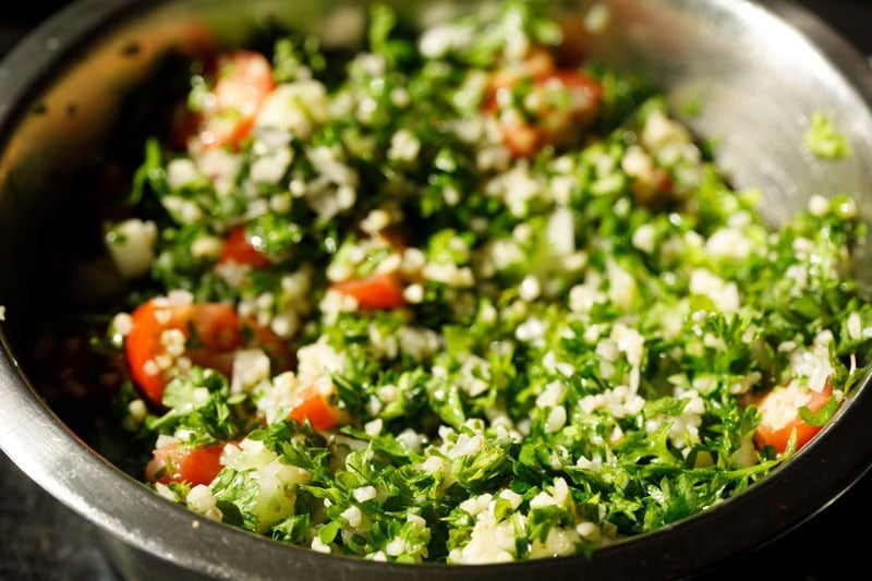 Parsley and other ingredients mixed to make tabbouleh salad.