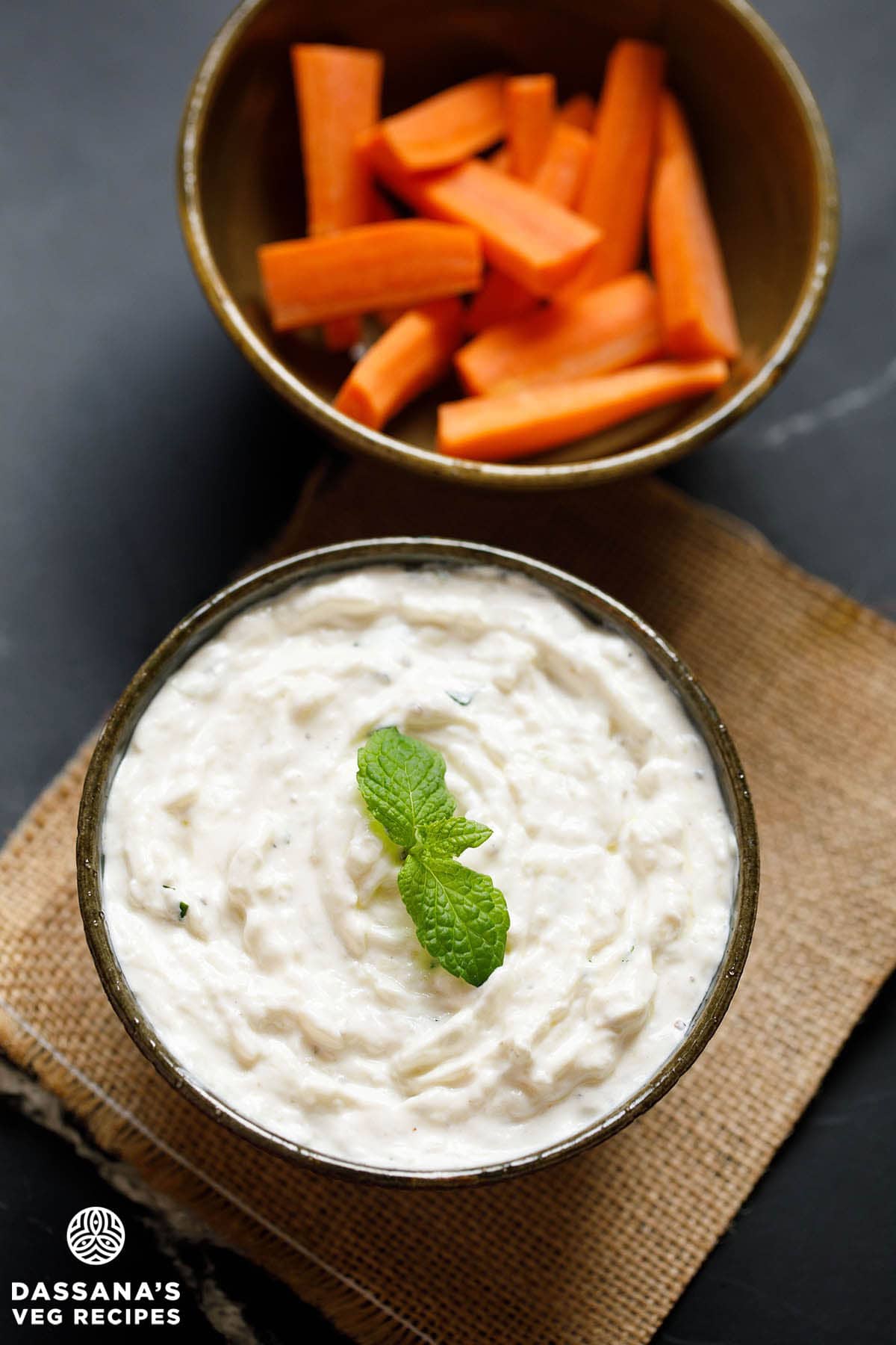 tzatziki sauce in a bowl with mint sprig garnish.