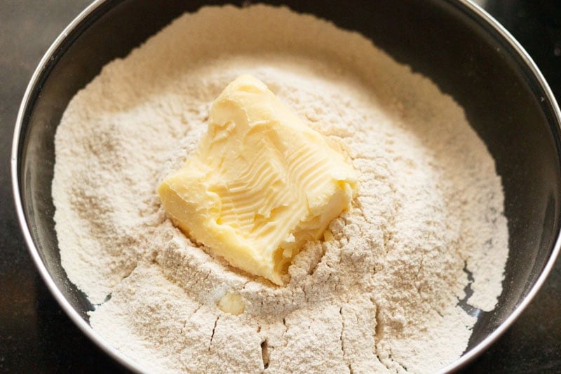 A slab of butter on flour in mixing bowl.