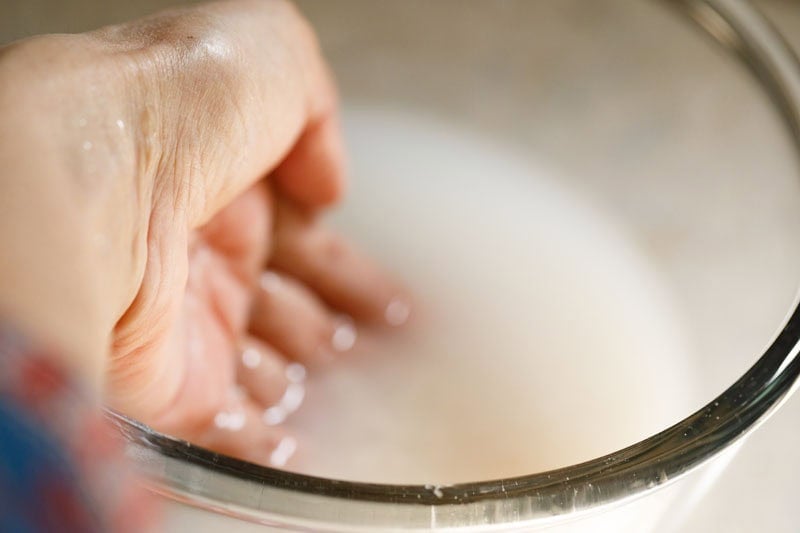 Swirling the rice grains in bowl with hands.