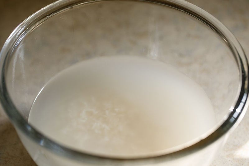 Starchy cloudy water above the jasmine rice in bowl.