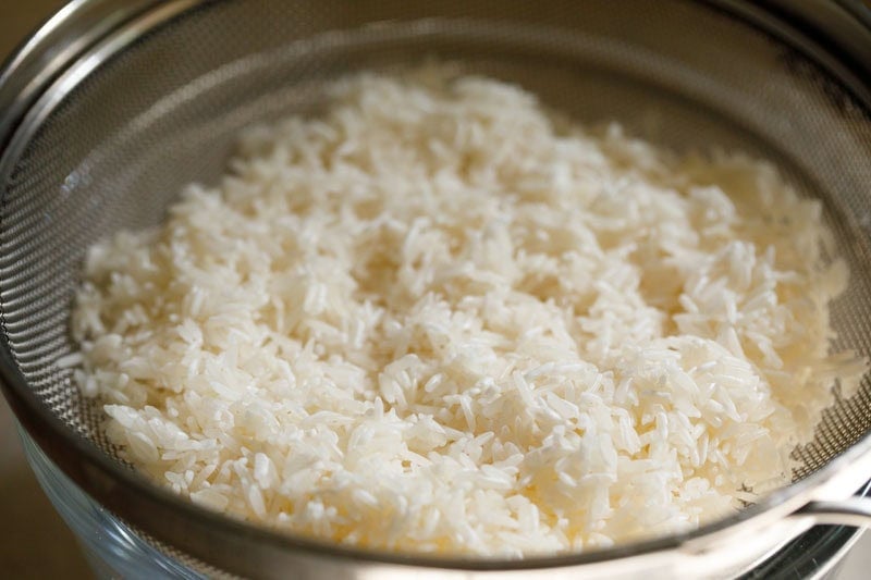 Rinsed jasmine rice in a mesh strainer.