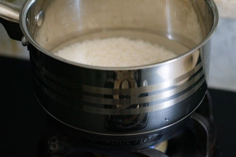 Pan with jasmine rice and water on stovetop.