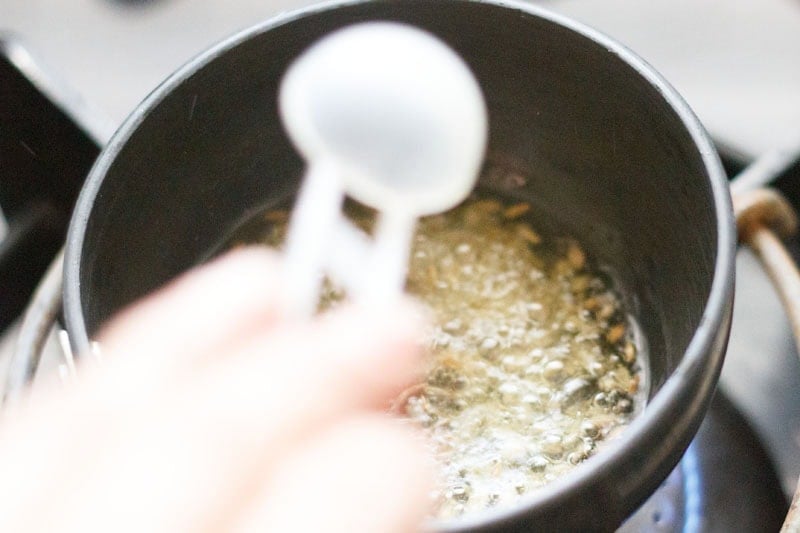 Adding cumin while tempering to make idli chutney or dosa chutney recipe.