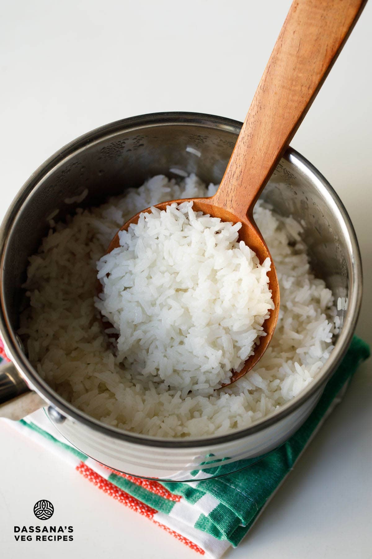 Perfect jasmine rice in a wooden spoon inside a pan.