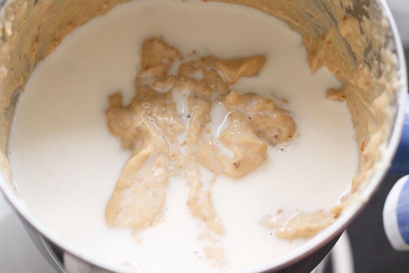 Creamy kaju shake mixture with milk in blender.