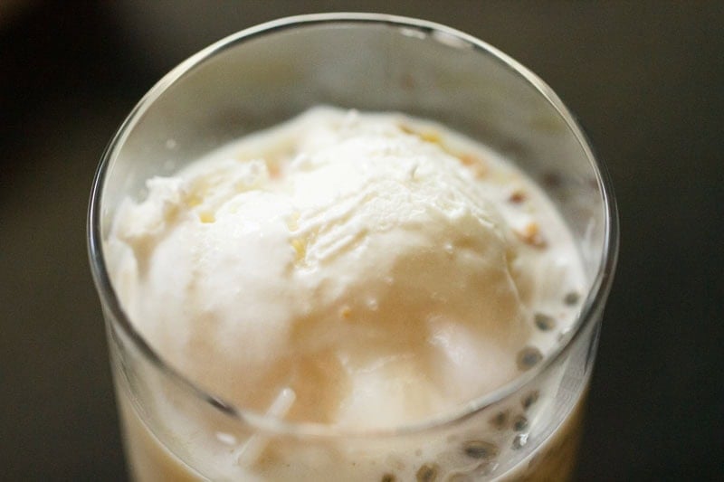 Scoop of vanilla ice cream in glass.