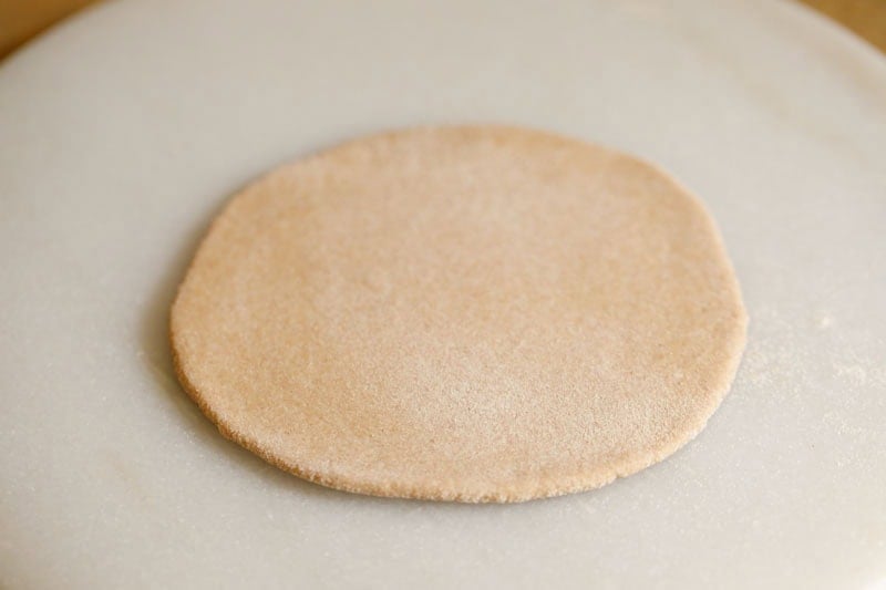 Round, uncooked dough on surface.