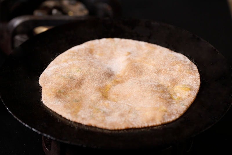 Cooking sattu paratha on skillet.