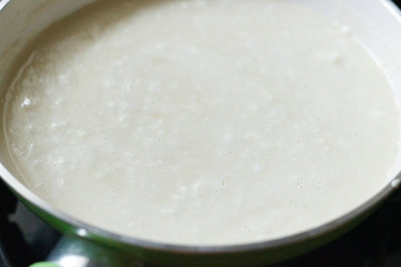 Cooking paneer barfi mixture in pan.