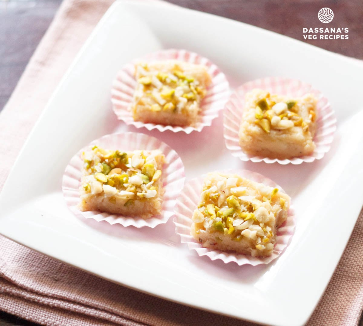 Malai Burfi squares on a white plate.