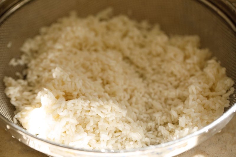 Soaked sticky rice in a strainer.