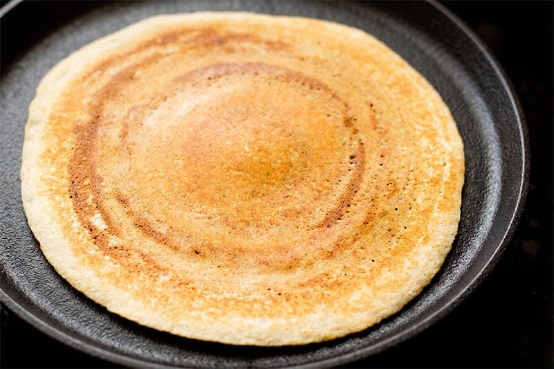 Golden, crispy and well cooked rice dosa on tawa.