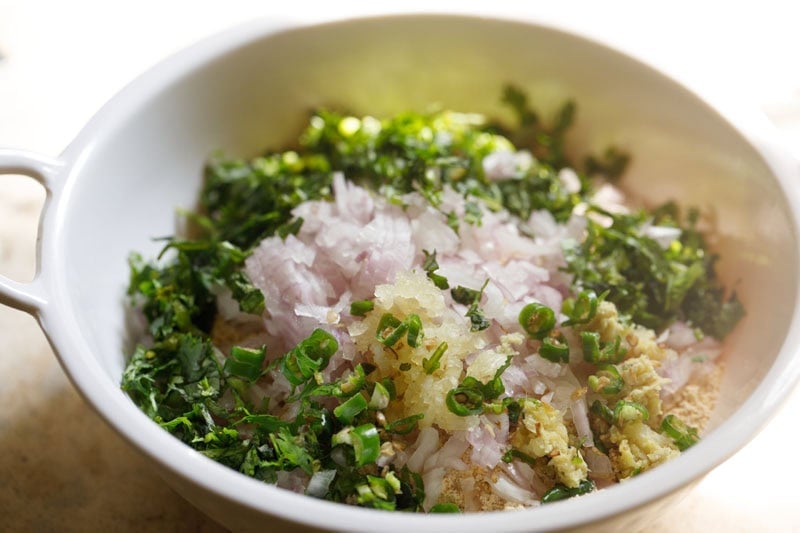 Chopped herbs and vegetables in bowl.