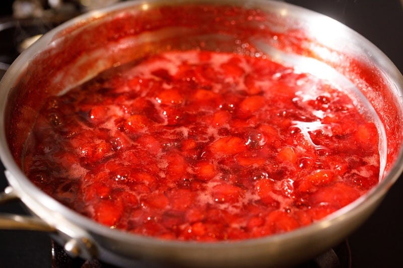 Strawberries simmering in pan.
