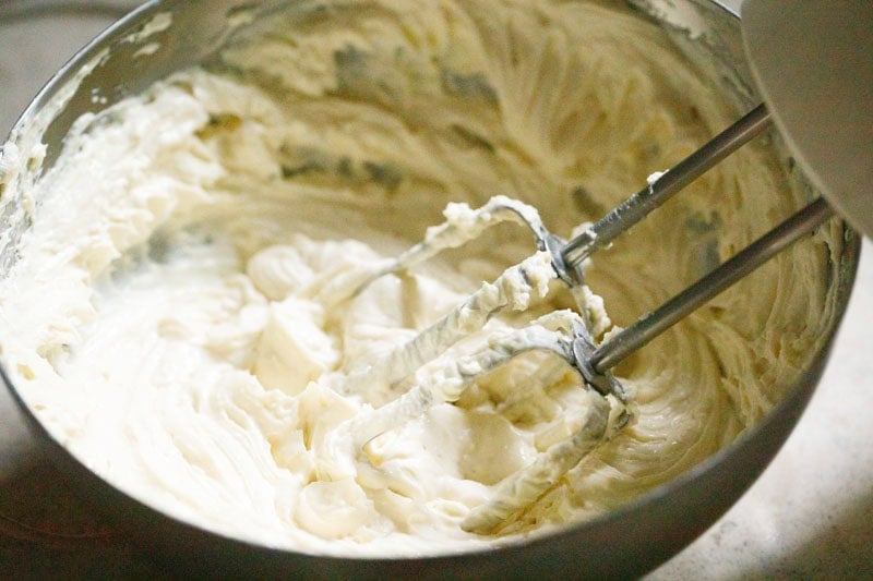 Whipping cream cheese with an electric whisk.