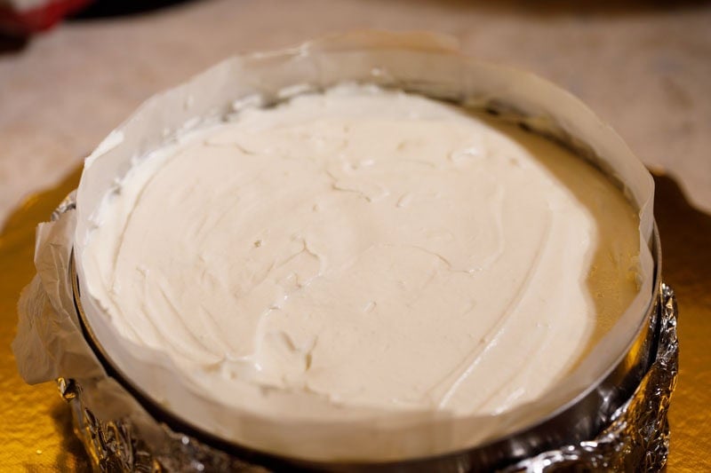 Leveled cheese cake mixture in pan.