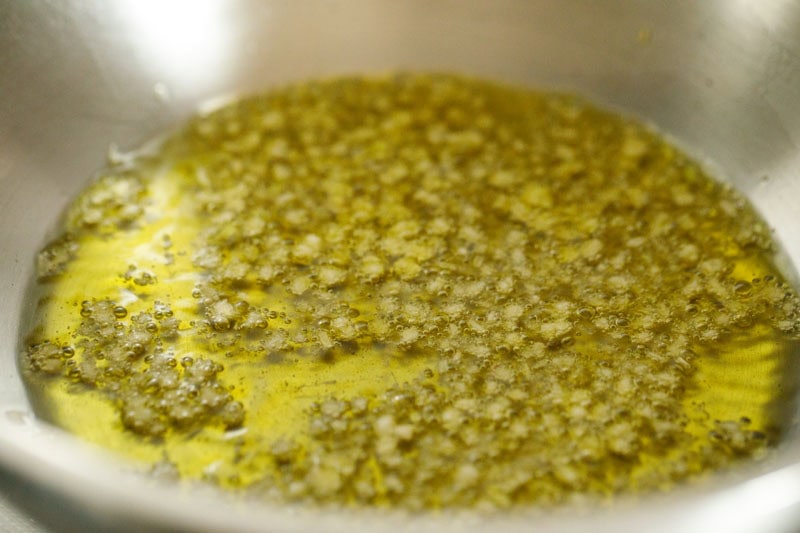 Garlic in olive oil in a pan.