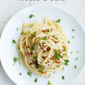 Plate of spaghetti aglio e olio​with herbs.
