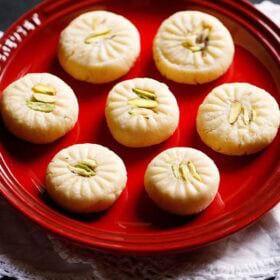 Milk peda on red plate.